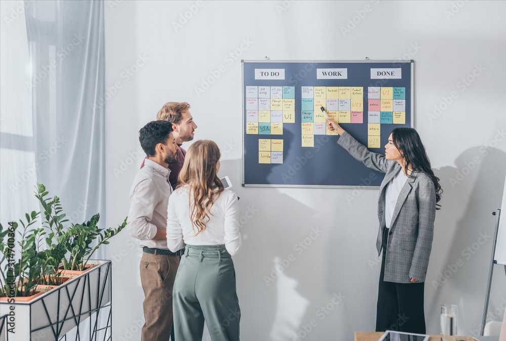 Ταπετσαρία attractive asian scrum master pointing at db design letters on sticky note near