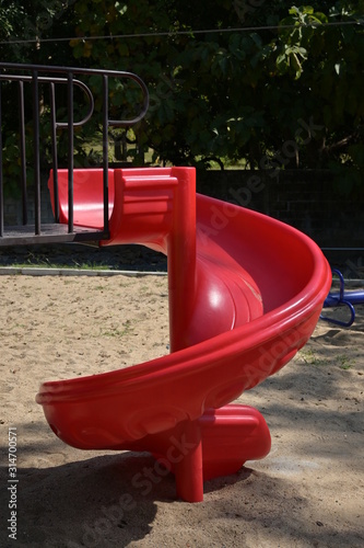 red slide for kid playing outdoor in sand playground