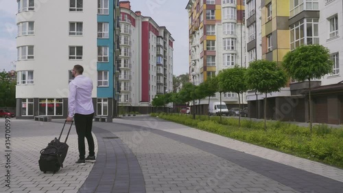 Wallpaper Mural Bearded man with suitcase talking on smartphone. Torontodigital.ca