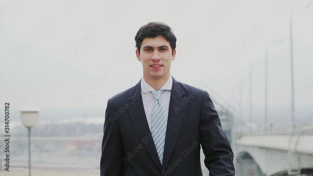 Successful Caucasian Guy businessman in a suit and tie is in a good mood, smiling, rejoicing in victory. Slow motion. Shooting on the Steadicam Successful Caucasian Guy businessman in a suit and tie is in a good mood, smiling, rejoicing in victory. Slow motion. Shooting on the Steadicam