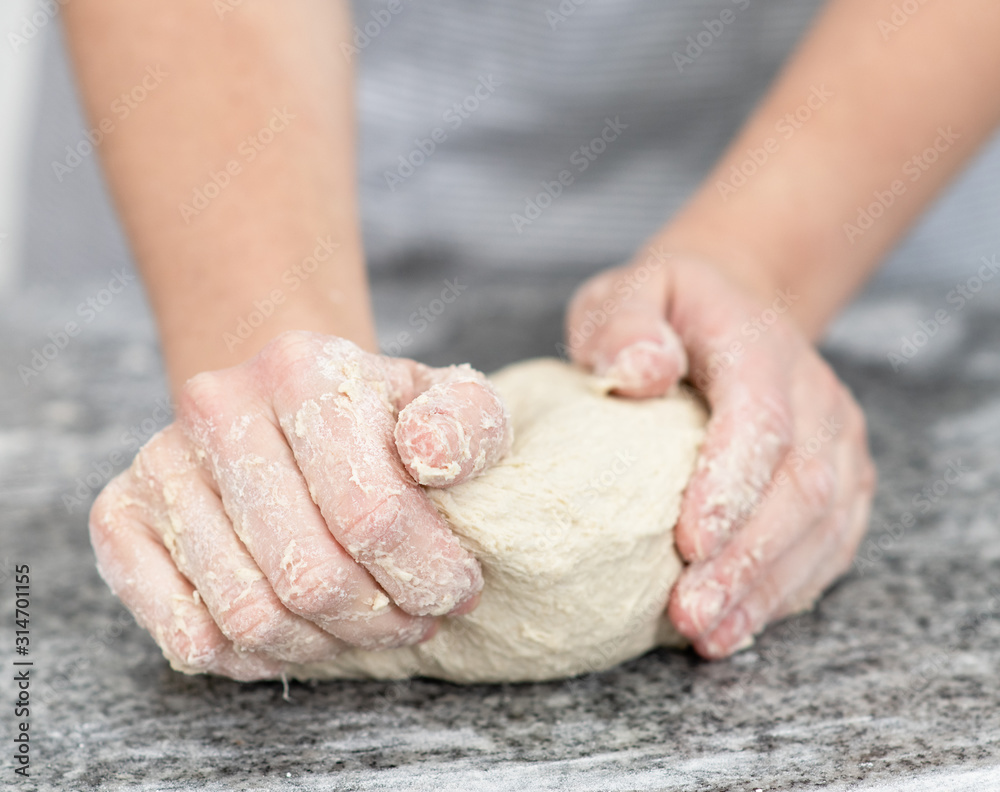 Close up woman`s hands making dough in the kitchen at home