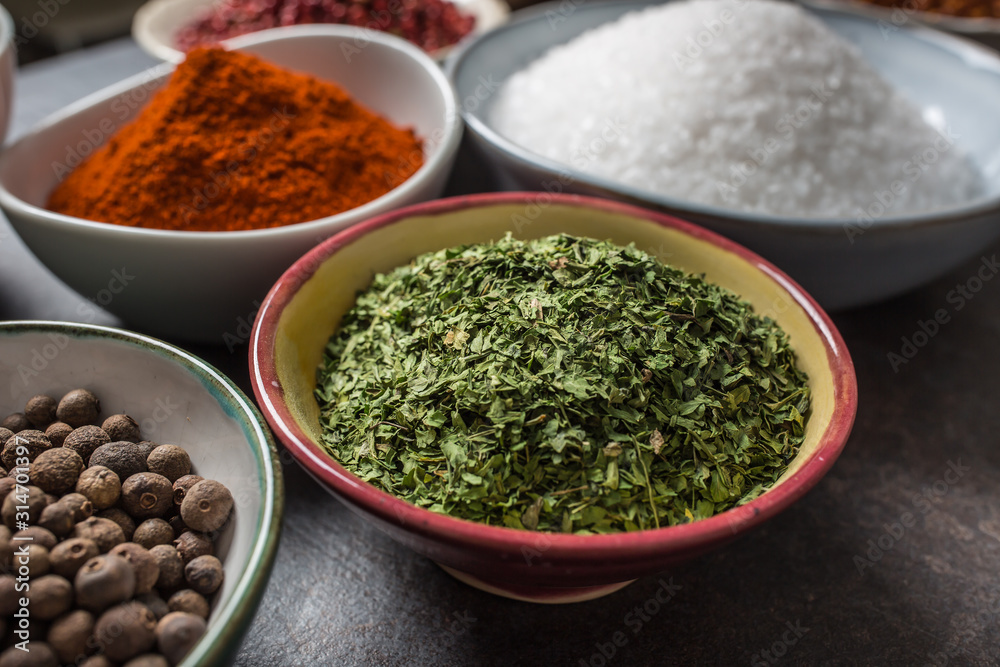Dried parsley and variety spices and herbs in bowls Dried parsley and variety spices and herbs in bowls