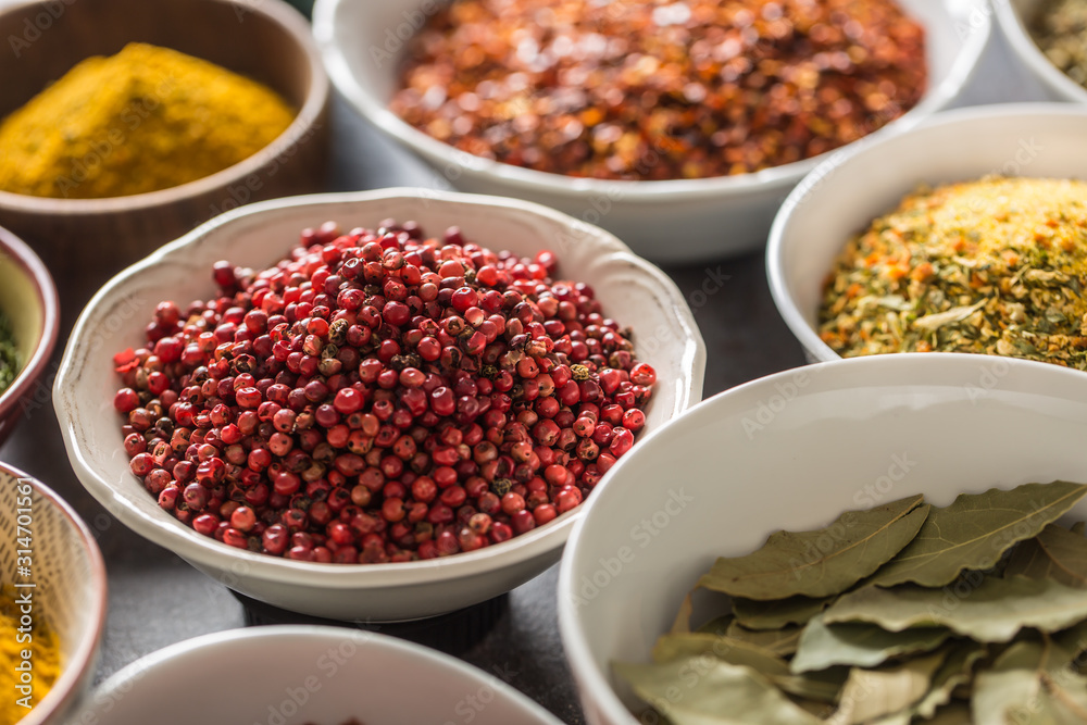 Pink peppercorn and variety spices and herbs in bowls Pink peppercorn and variety spices and herbs in bowls