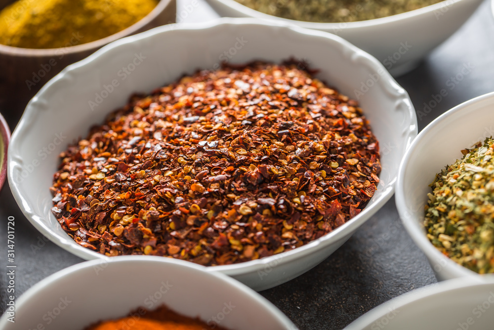 Ground chilli pepper and variety spices and herbs in bowls Ground chilli pepper and variety spices and herbs in bowls