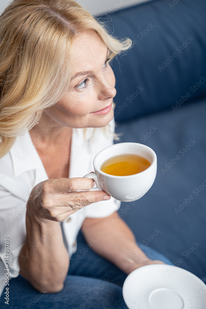 Modern attractive Caucasian businesswoman drinking herbal tea