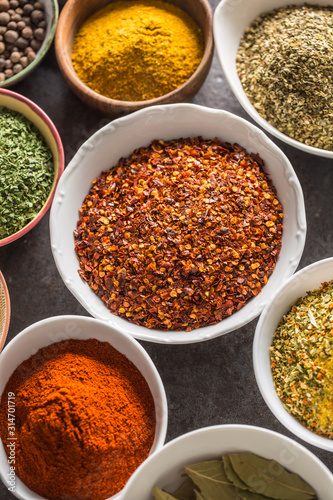 Ground chilli pepper and variety spices and herbs in bowls