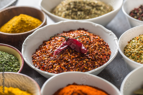 Ground chilli pepper and variety spices and herbs in bowls