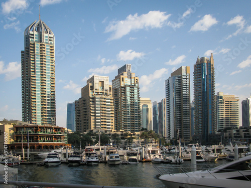 modern skyscrapers against the blue sky in the Dubai Marina district, boats and yachts in the foreground, UAE © Mentor56