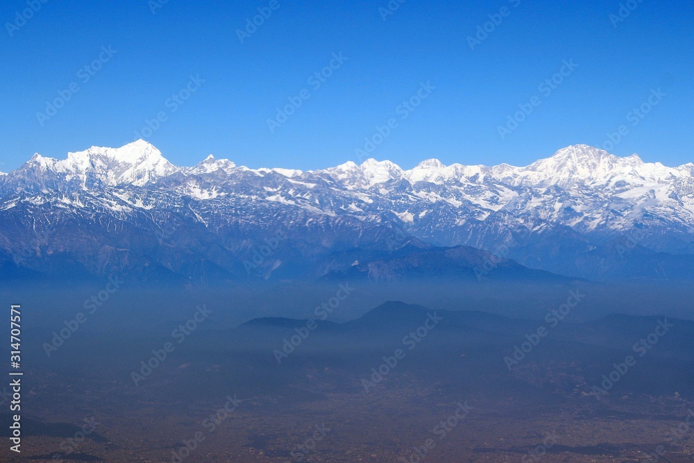 Scale of the Himalayas / Enormous of the Himalaya ranges above the cloud and layer of dust over Nepal Scale of the Himalayas / Enormous of the Himalaya ranges above the cloud and layer of dust over Nepal
