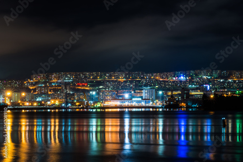 night Murmansk  city lights reflected in the Bay and the ships standing in the port