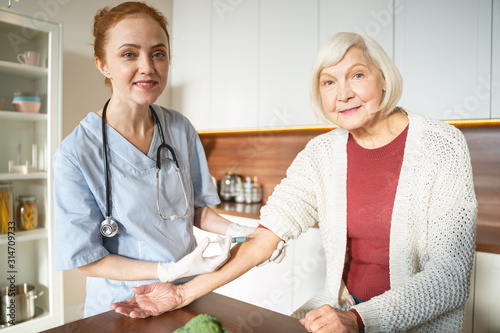 Delighted medical worker standing near her patient