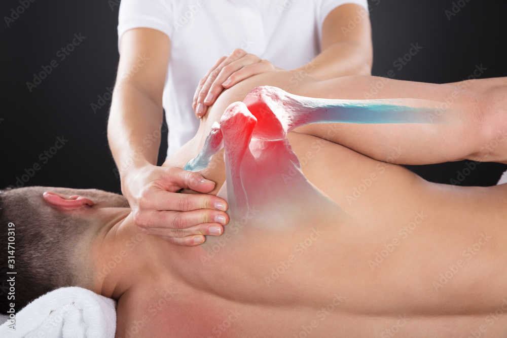 Naklejka premium Physiotherapist Doing Treatment On Man's Shoulder