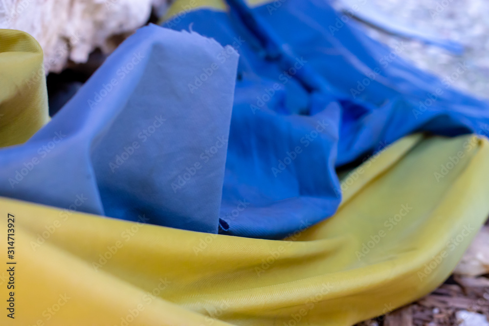 Torn closeup of an ukranian flag, destroyed , ruined , cut. Symbol of conflict and war in ukraine