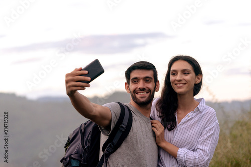 Couple taking selfie photo with smart phone hiking on mountain. © pigprox