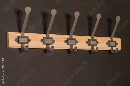  A cloth hanger made of wood and iron on a black wall
