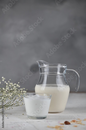 Dairy products, milk, yogurt, sour cream, kefir, in a glass and a jug. Vertical