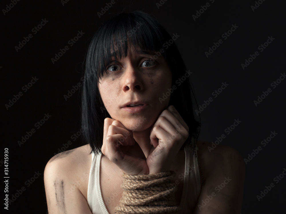 Young woman with bound hands on black background. Young woman with bound hands on black background.