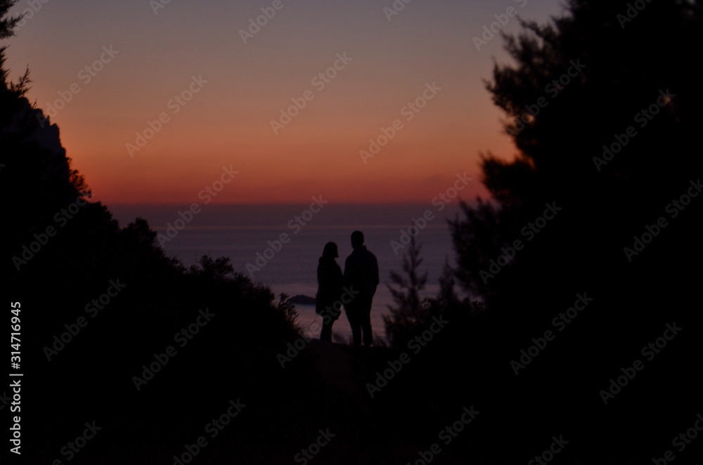 silueta de una pareja mirando el calido atardecer en la isla de ibiza