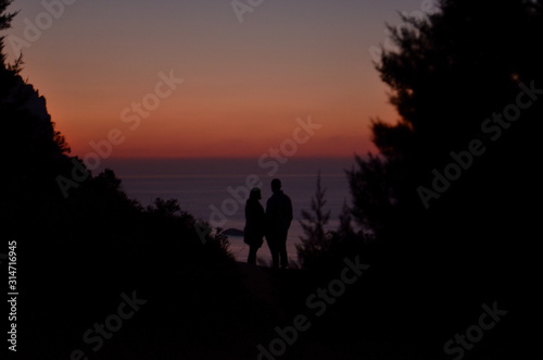 silueta de una pareja mirando el calido atardecer en la isla de ibiza