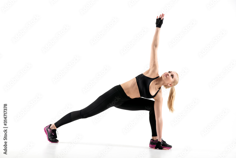 Fototapeta premium The girl performs a muscle stretching exercise during training.