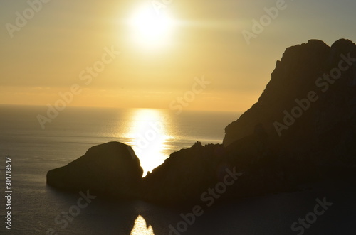 Luz del sol al atardecer pasando entre las rocas de la isla