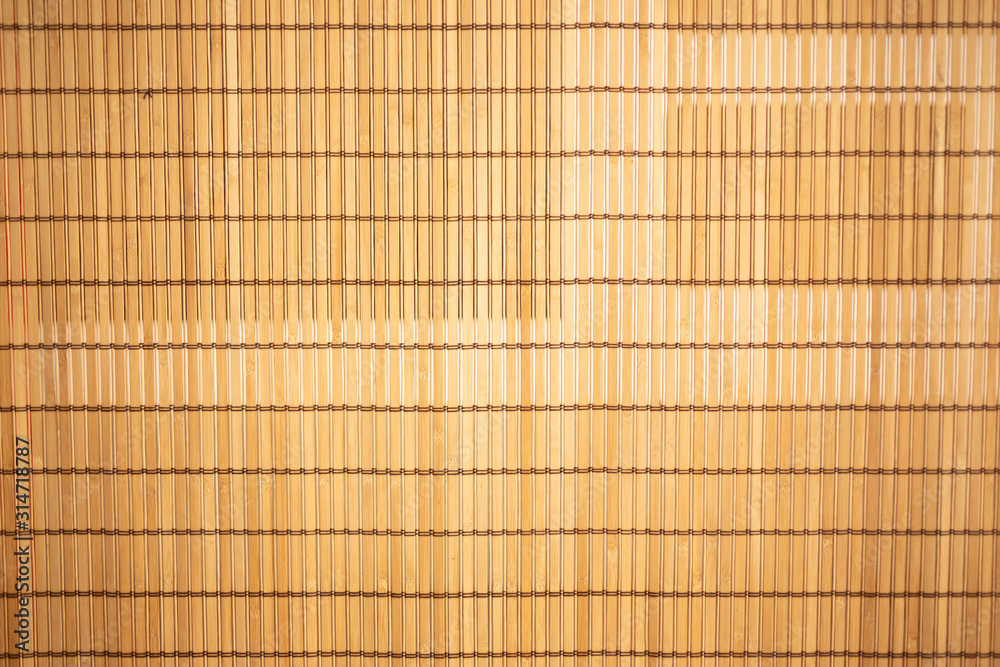 A background image of a bamboo facade or room divider. 