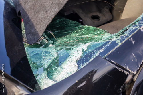 A view of a shattered window and body damage on a wreck vehicle.