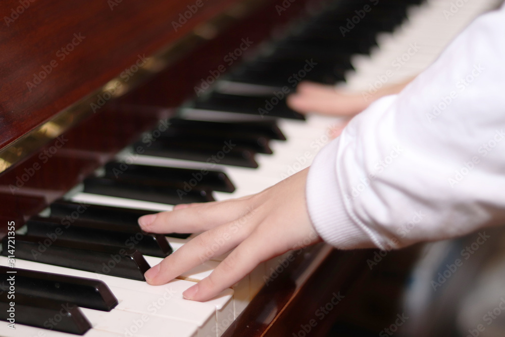 The piano close up. Black and white keys.Hands of a child playing the piano