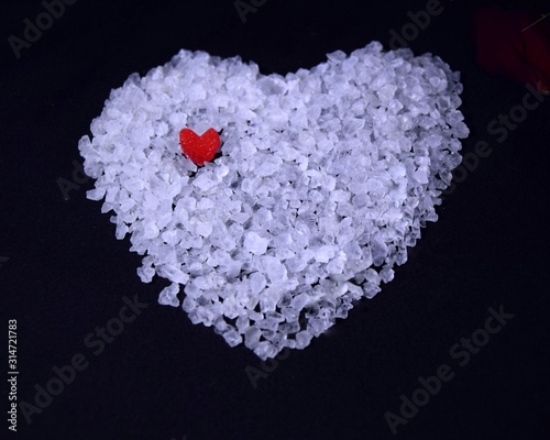 white heart of sea salt on a dark background with a place for the inscription. selective focus. holiday Valentine s day