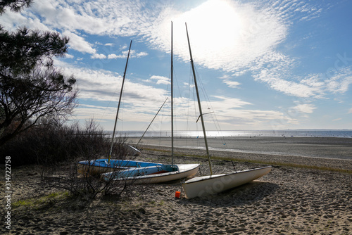 small sail boat in sand beach in Arcachon bay in Andernos France
