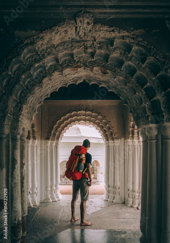 Backpacker under the arches of an Hindu temple, in Bangladesh