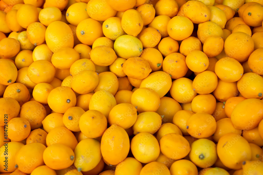 A background full of yellow meyer lemon on display at a local farmers market. A background full of yellow meyer lemon on display at a local farmers market.