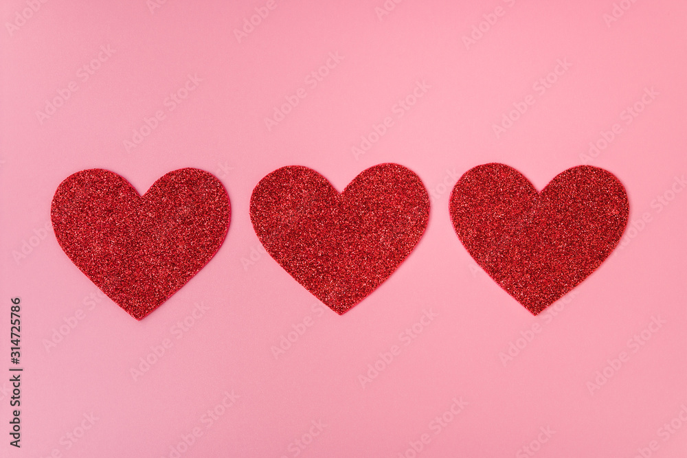 Three red heart shape figures on background Three red heart shape figures on background