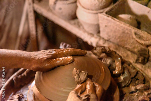Indian potter making clay pots on pottery wheel in Dharavi Slum at Mumbai photo