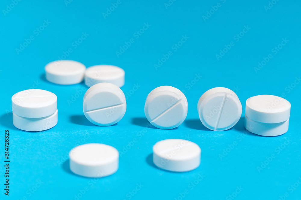white tablets, close-up, on a blue background, space for text.