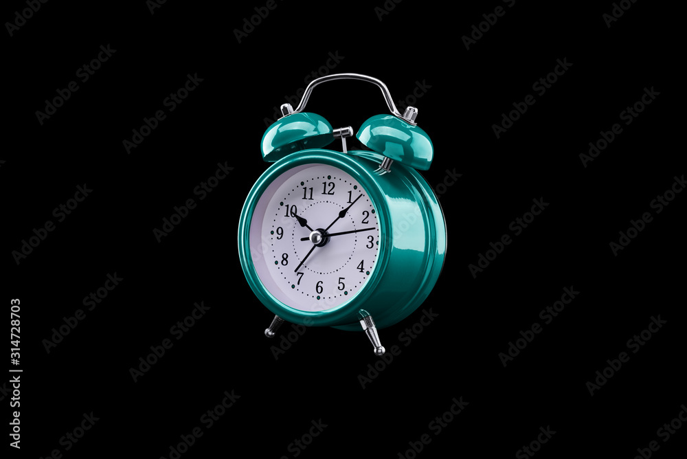 Turquoise alarm clock close-up isolated on dark background. Turquoise alarm clock close-up isolated on dark background.