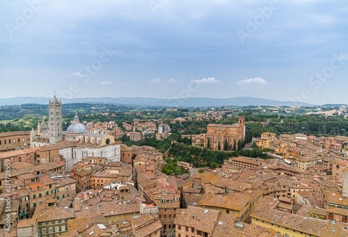 Stadt Siena Draufsicht Häuser und Dom im Vordergrund im Hintergrund Hügel und Himmel © Roger