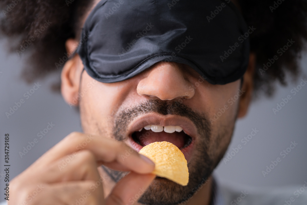 Portrait Of Blindfolded Man Tasting Food Portrait Of Blindfolded Man Tasting Food