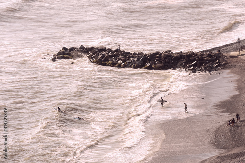 People inning the sea with surfboards in Miraflores, Lima, Peru photo