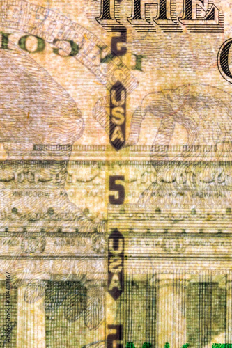 Plastic security strip inside 5 USD banknote. Security strip on American banknote created to prevent counterfeiters.