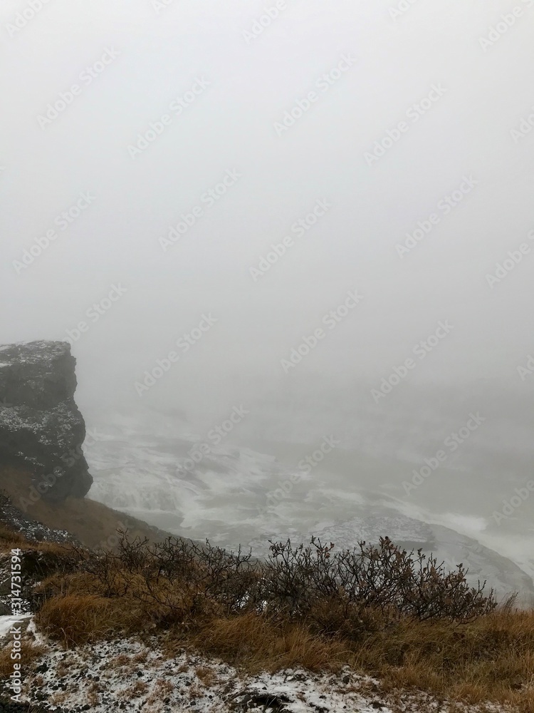 Majestic landscape of Gullfoss (golden waterfall) in Iceland on a cold November day: Outdoor scenery with water flowing down rocks and cliffs in a beautiful wild park in arctic North Europe