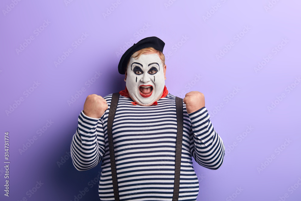 emotional plump actor with wide open mouth expressing his joy. isolated blue background, studio shot.