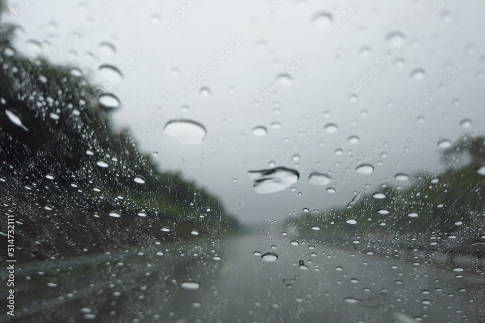 Rain drop falling on car windshield, drive car on street in city in heavy rain Rain drop falling on car windshield, drive car on street in city in heavy rain