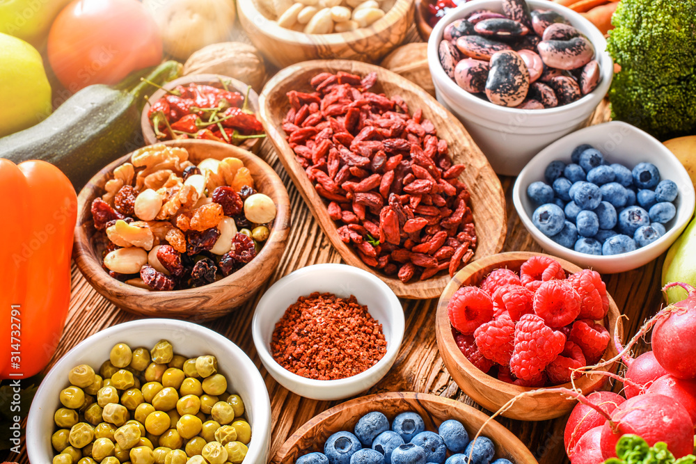 Healthy food eating variety selection in bowls: vegetables, fruits, berries, seeds, superfood, cereal, leaf vegetable on colorful background. Healthy food eating variety selection in bowls: vegetables, fruits, berries, seeds, superfood, cereal, leaf vegetable on colorful background.