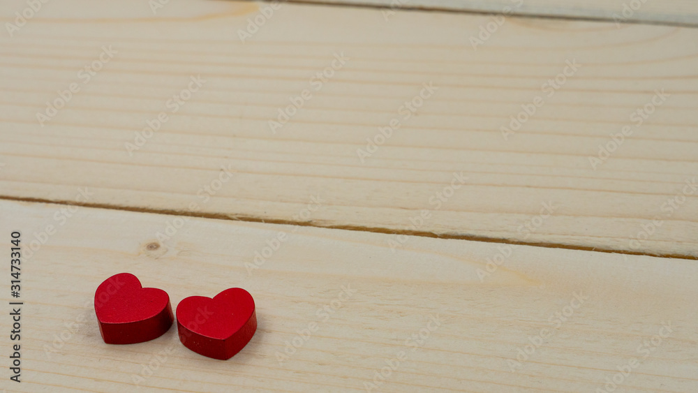 Two red hearts lying on a wooden table. Two red hearts lying on a wooden table.