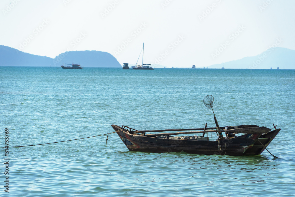 Beautiful seascape, view of the pier in Thailand. Fishing boat moored near the shore.