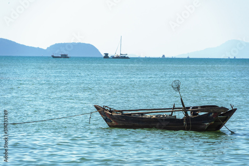 Beautiful seascape  view of the pier in Thailand. Fishing boat moored near the shore.