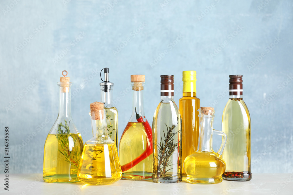 Different sorts of cooking oil in bottles on light grey table Different sorts of cooking oil in bottles on light grey table