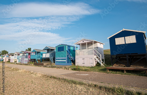 Colourful wooden beach huts facing the ocean at Whitstable coast, Kent district England.