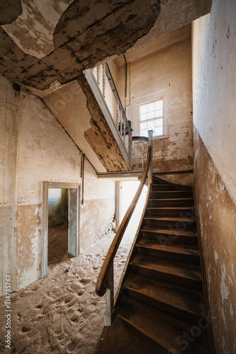 Old staircase in abandoned house filled with sand, Kolmanskop Ghost Town, Namibia © wideeyes